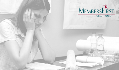 woman sitting at desk seemingly upset about finances