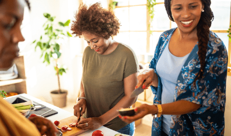 Group of 3 African American women in kitchen preparing a meal